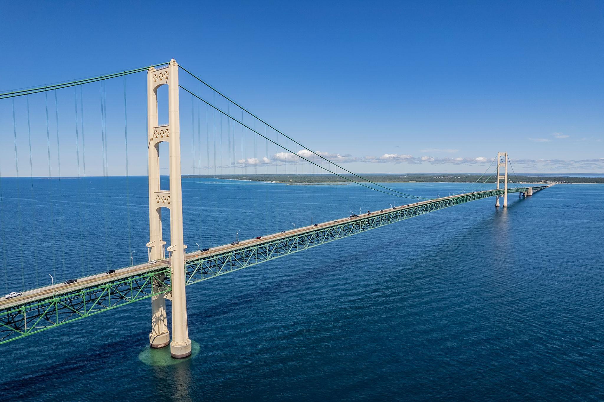 Aerial view of the Mackinac Bridge spanning the Straits of Mackinac under a clear blue sky